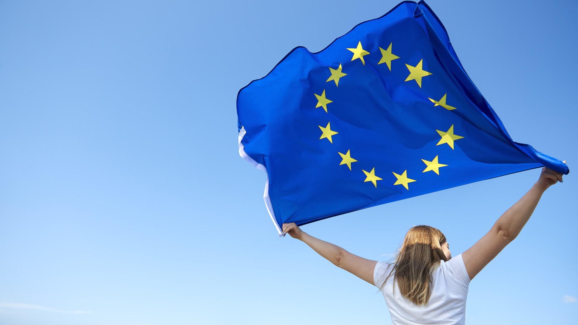 © iStock rueckansicht-der-jungen-frau-die-die-flagge-der-europaeischen-union-schwenkt.jpg