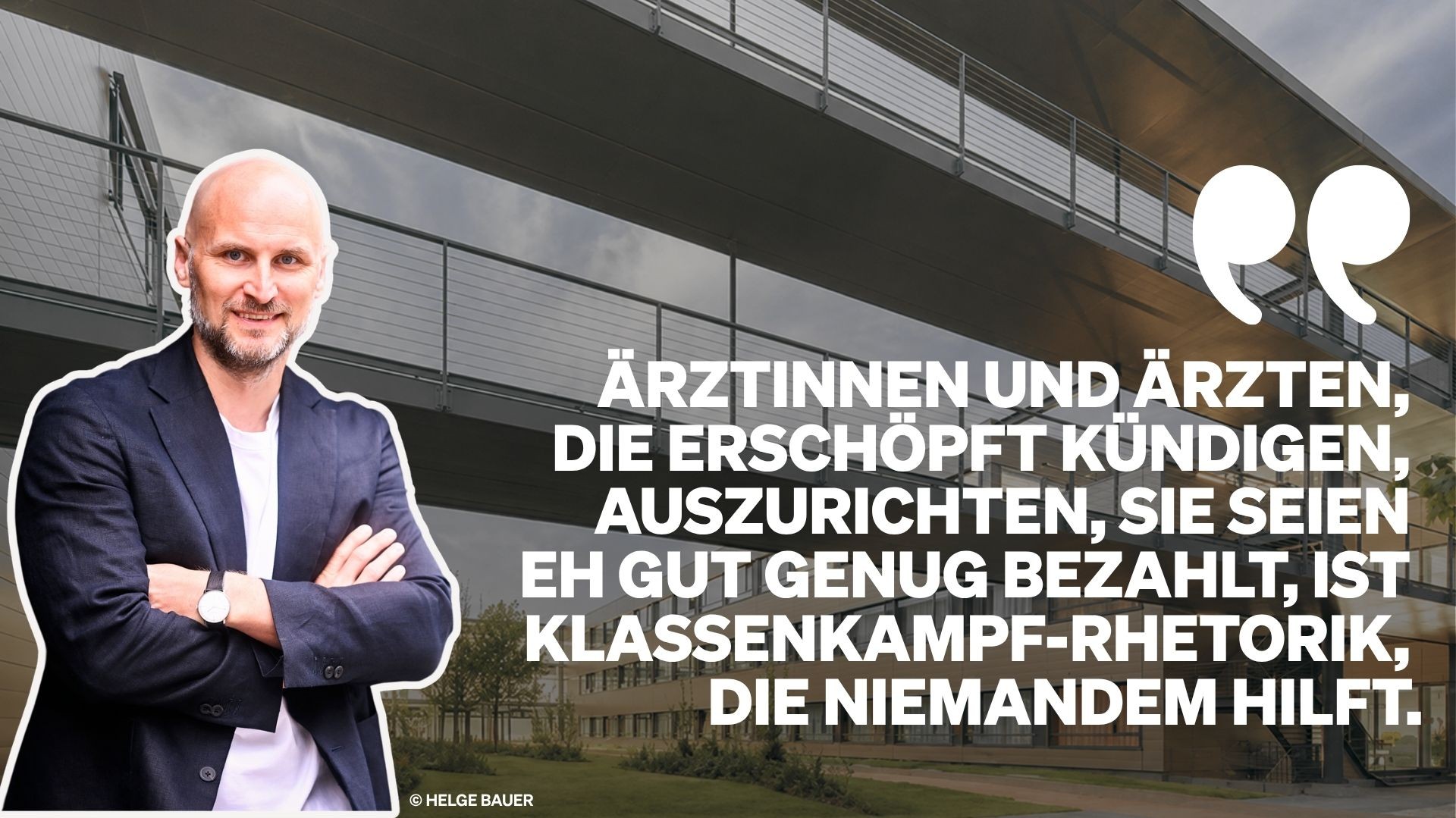 Helge Bauer mit verschränkten Armen vor einem modernen Gebäude.
