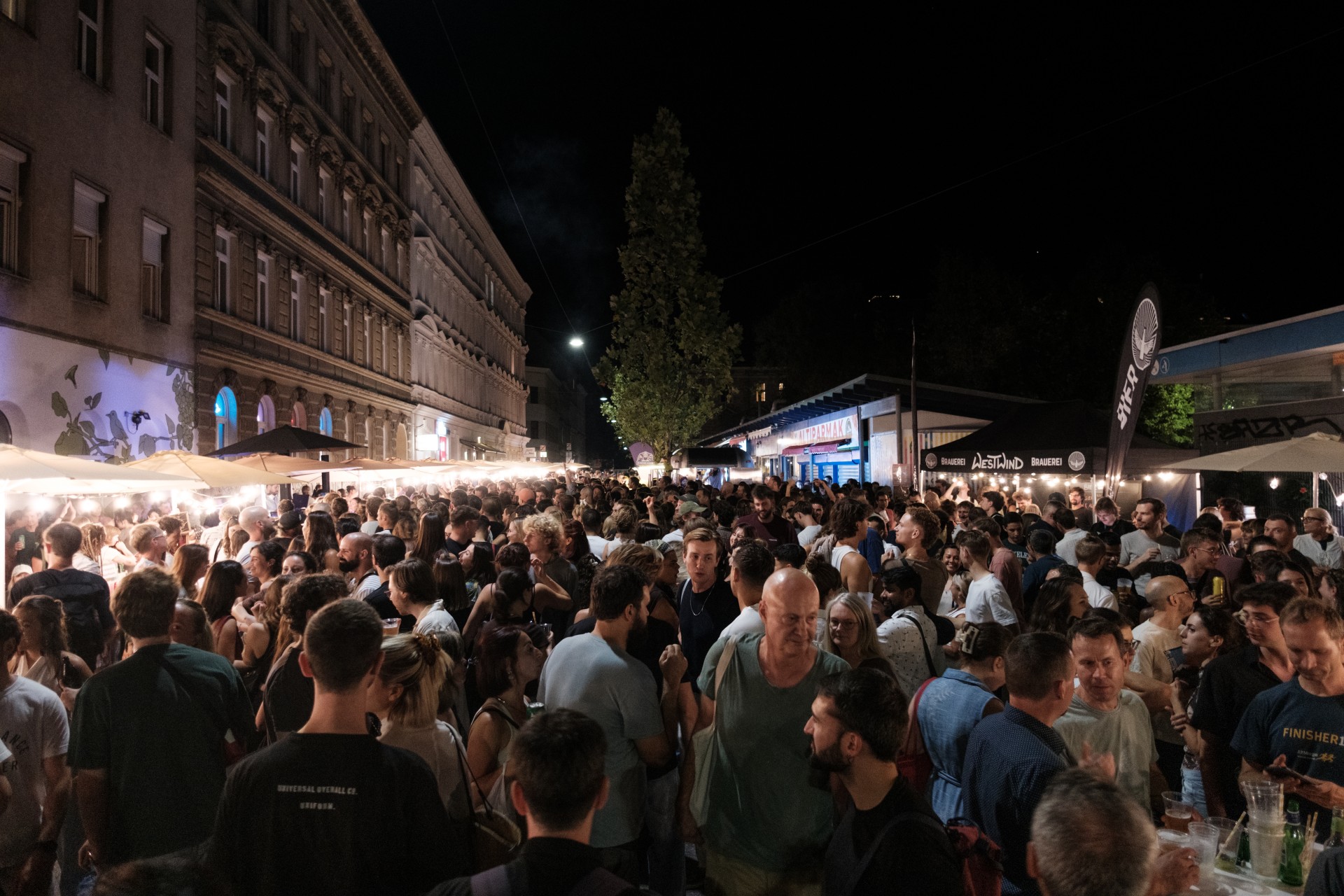 Zahlreiche Besucher:innen der Langen Nacht der Wiener Märkte bei Nacht.