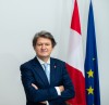 Helumt Brandstätter NEOS EU Spitzenkandidat mit EU-Flagge und Österreich-Flagge im Hintergrund 