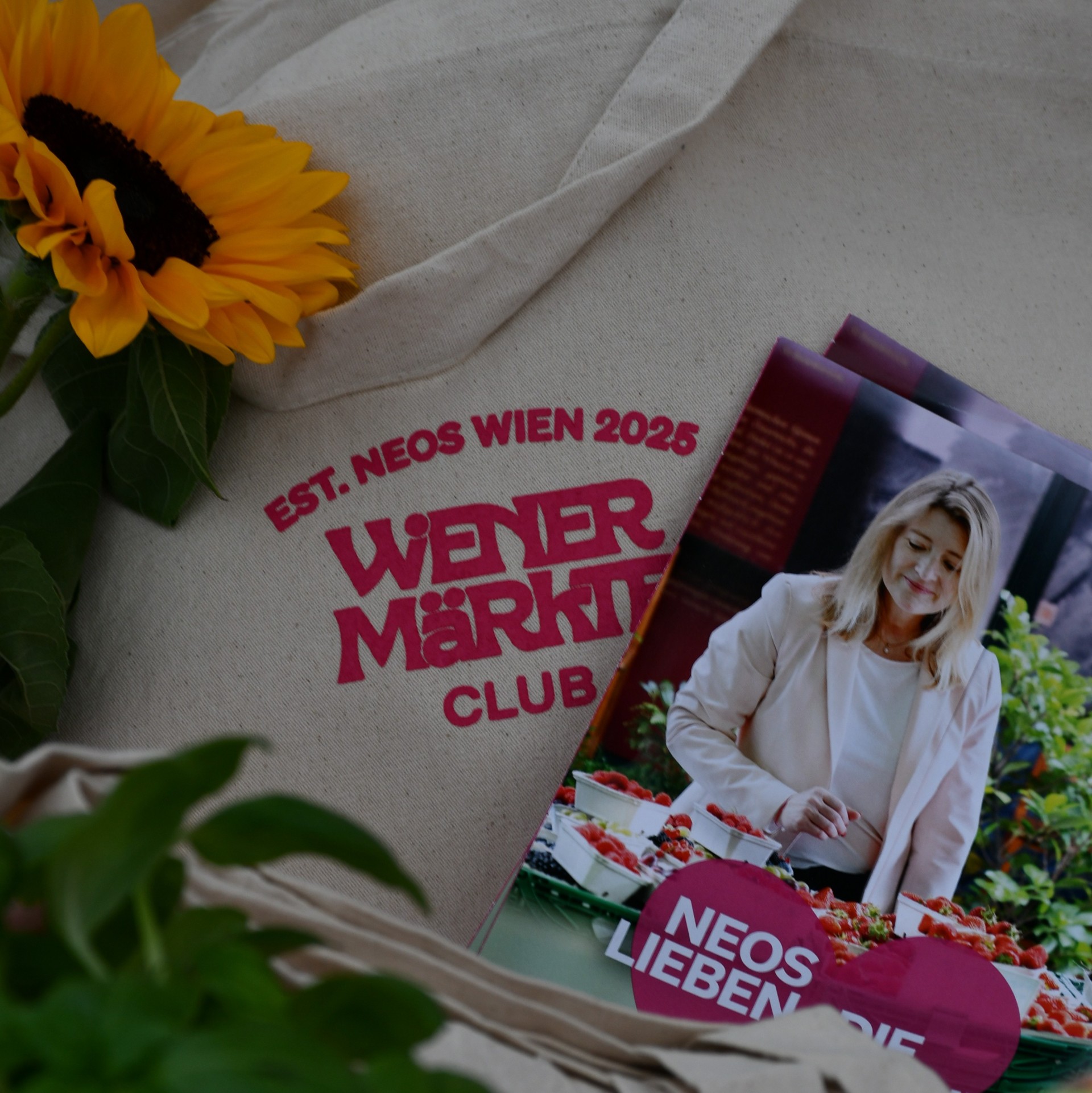 Nahaufnahme einer Stofftasche des Wiener Märkte Clubs mit pinken Illustrationen verschiedener Marktprodukte.