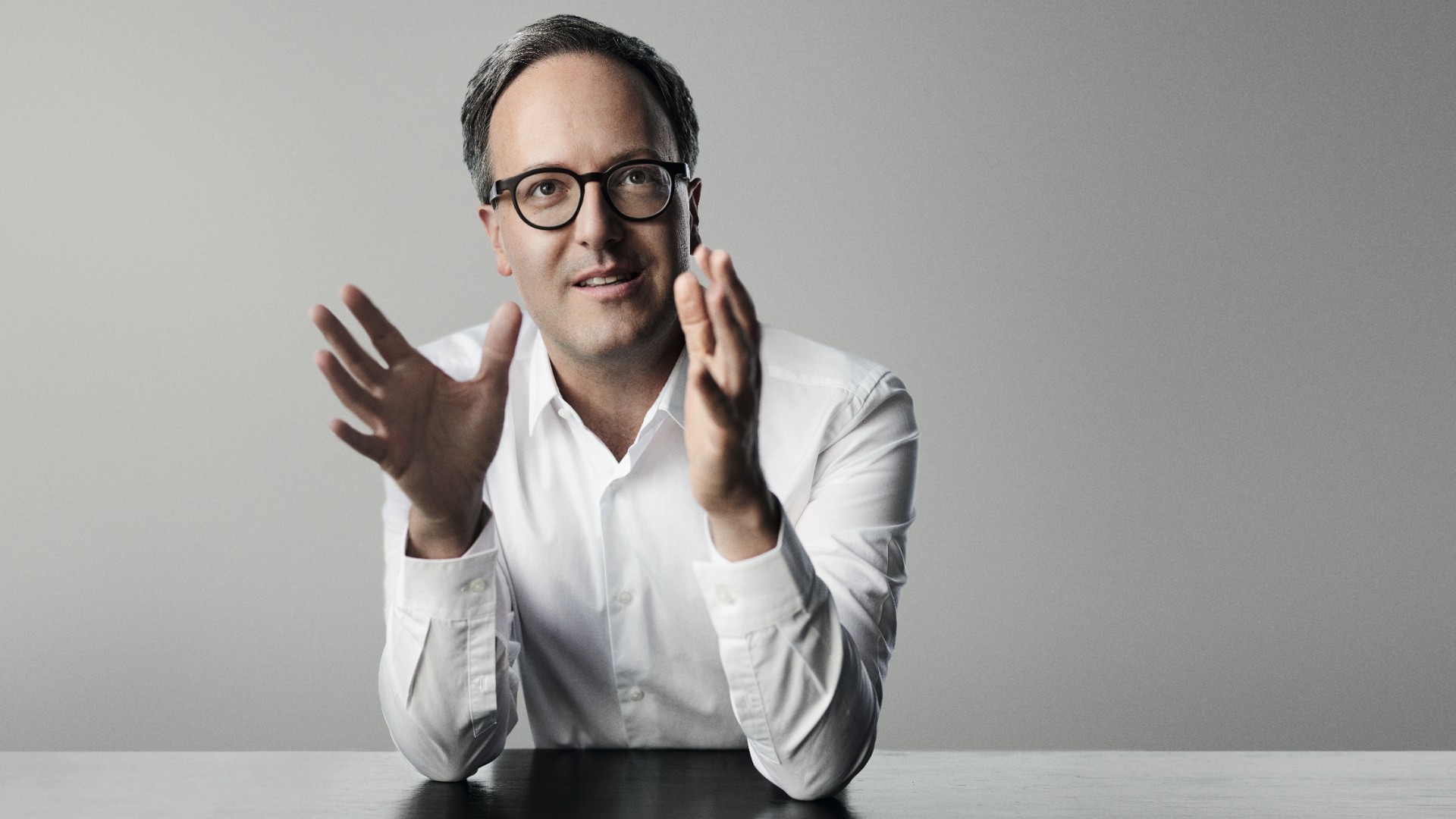 Dominik Oberhofer spricht vor der Kamera und sitz