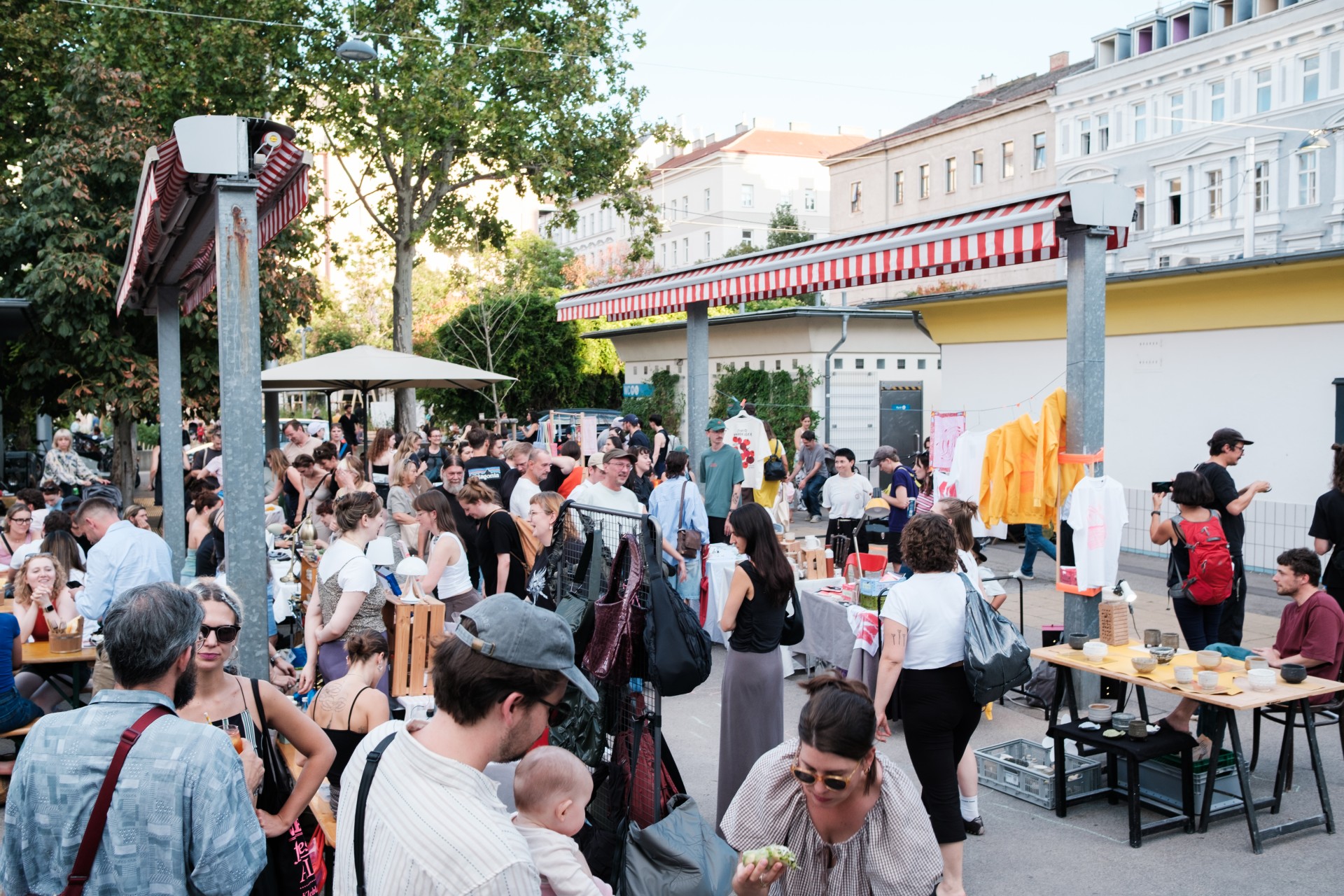 Zahlreiche Gäste flanieren auf einem Wiener Markt.