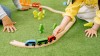 Kinderhände, die mit einer Holz-Eisenbahn spielen