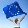 rueckansicht-der-jungen-frau-die-die-flagge-der-europaeischen-union-schwenkt-4668x4670