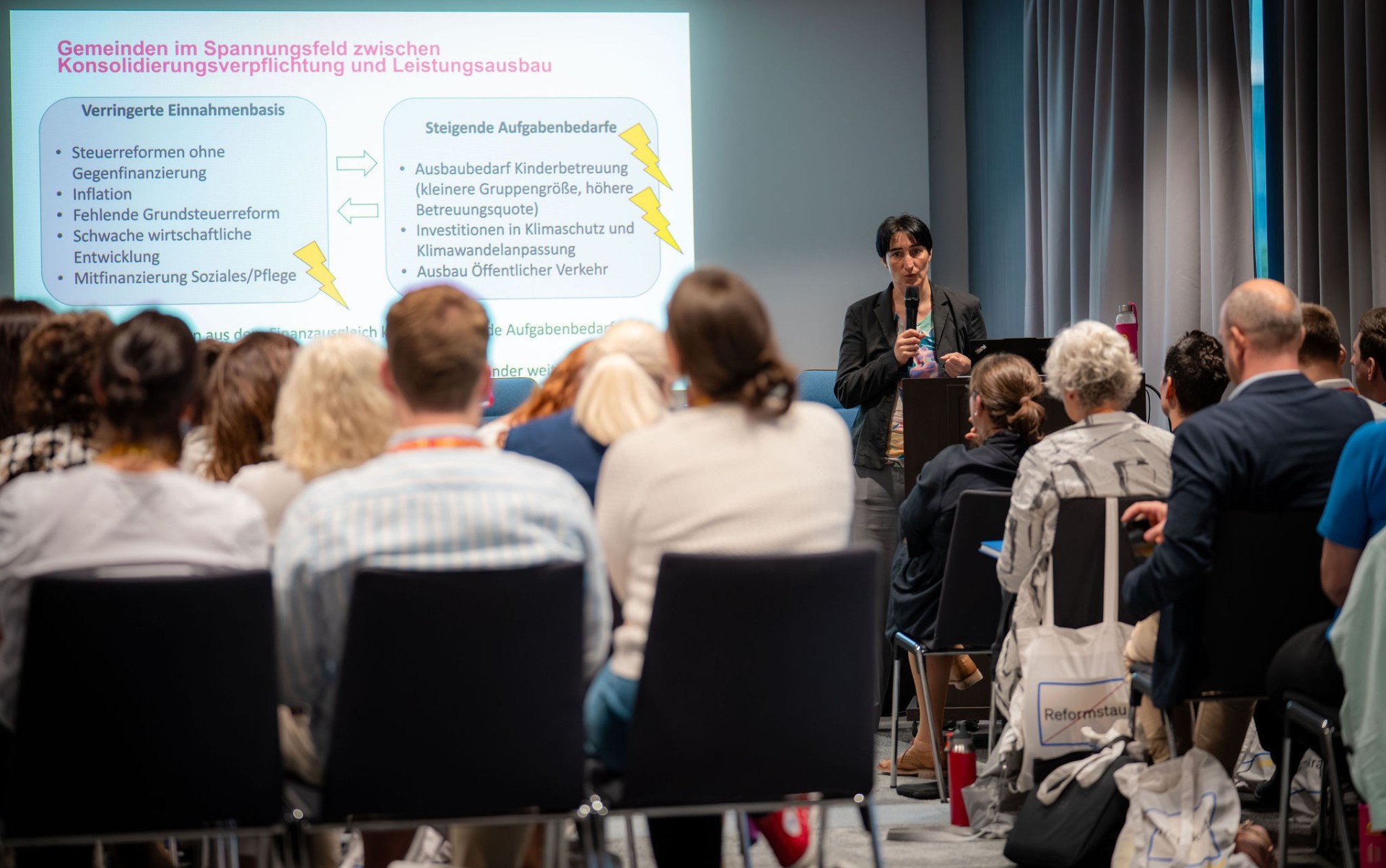 Karoline Mitterer spricht vor einer Gruppe von Menschen