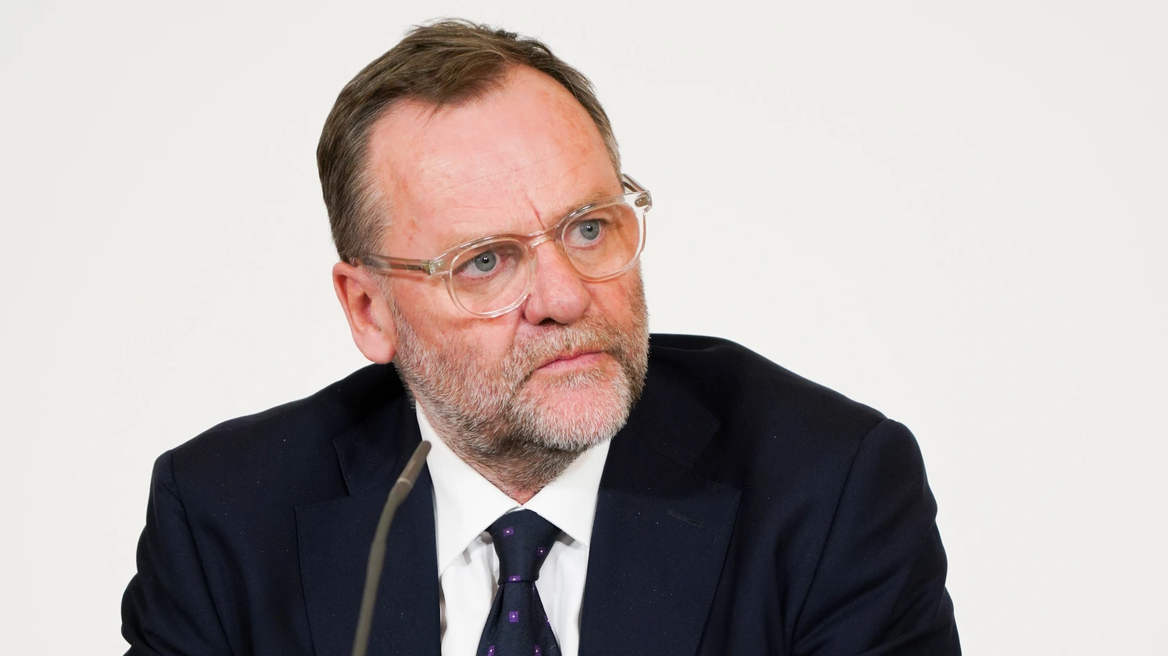 Hans-Peter Doskozil, Landeshauptmann, mit Brille und Anzug vor weißem Hintergrund.