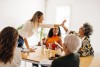 Frauen in einem Konferenzraum, zwei klatschen ab